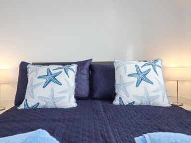 A bedroom with pillows, a lamp and a bed at Poldam in St Austell