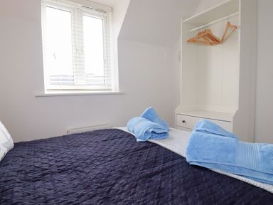 A bedroom with a bed and wardrobe at Poldam in St Austell
