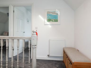 A hallway with a door and radiator at Poldam in St Austell
