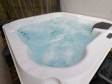 A hot tub filled with water at Poldam in St Austell