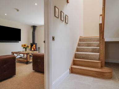 A living room with a television and a fireplace at Foxes Den in Pendomer near Yeovil, Somerset