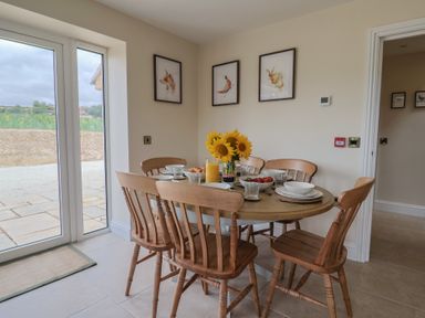 A dining room with a round table set for a meal at Foxes Den Pendomer near Yeovil Somerset