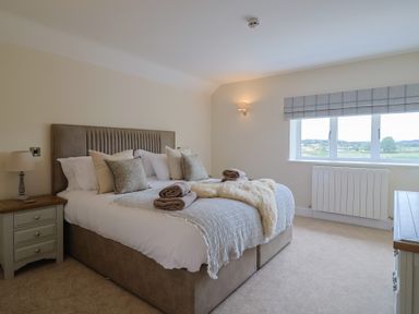 A bedroom with a bed and window at Foxes Den in Pendomer near Yeovil, Somerset
