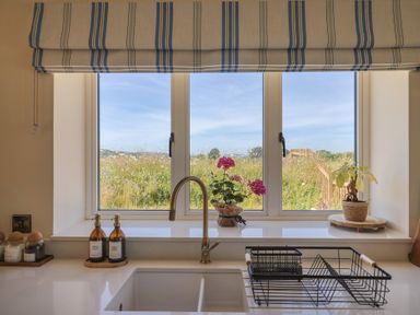 A kitchen with a window and dishes available at The Fox Den in East Coker