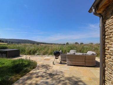 An outdoor area with a sofa and barbecue grill at The Fox Den in East Coker