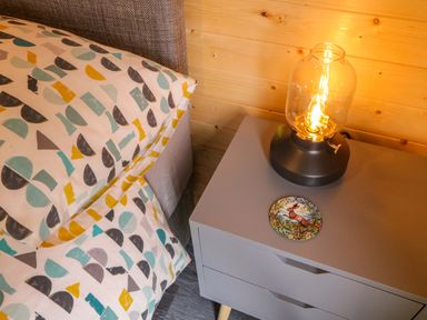 A bedside table with a lamp and pillow at Alken The Hare in Bushmills