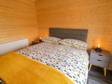 A bedroom with a double bed and nightstand at Alken The Hare in Bushmills