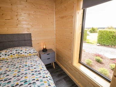A bedroom with bed and nightstand at Alken The Hare Bushmills