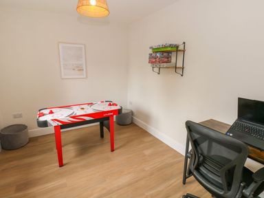 A game room with an air hockey table and a desk at Hafan Y Gof in Newcastle Emlyn