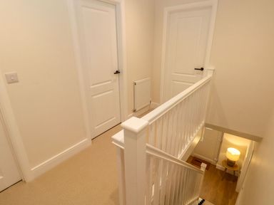 A hallway with a staircase and doors at Hafan Y Gof Newcastle Emlyn