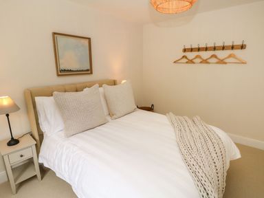 A bedroom with a bed and coat hangers at Hafan Y Gof in Newcastle Emlyn