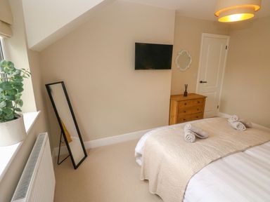 A bedroom with bed, television and mirror at Hafan Y Gof in Newcastle Emlyn