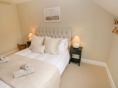 A bedroom with a bed and nightstand at Hafan Y Gof in Newcastle Emlyn