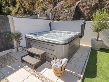 A hot tub with steps and towels in the garden at Hafan Y Gof Newcastle Emlyn