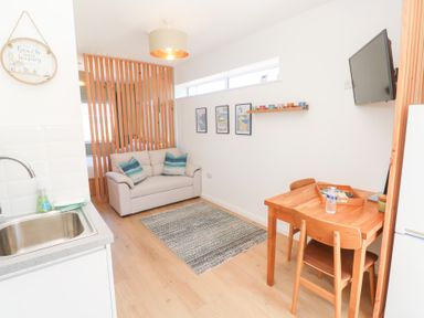 A living room with a sofa and dining table at Carn Brea Redruth