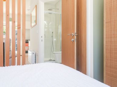 A bedroom with wooden door and shower area at Carn Brea in Redruth
