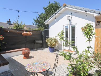A garden with a table and chairs at Carn Brea in Redruth