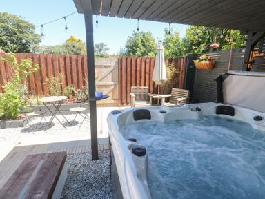 A garden with a hot tub and seating area at Carn Brea in Redruth