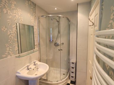 A bathroom with shower and sink at Stoker’s Cottage, Windermere