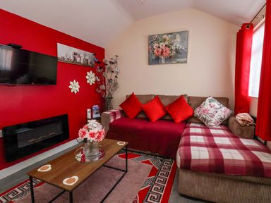 A living room with a television and sofa at Sandbay in Bridlington