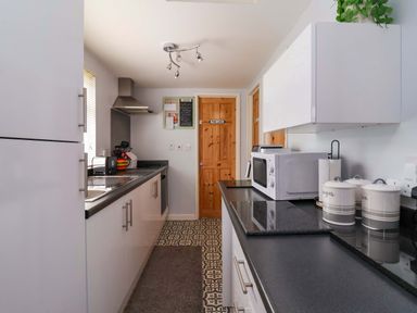 A kitchen with cabinets and a microwave at Sandbay in Bridlington