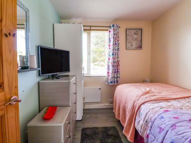 A bedroom with a bed and television at Sandbay in Bridlington