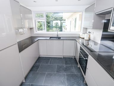 A kitchen with cabinets and a sink at Lifeboat Lookout in Tenby