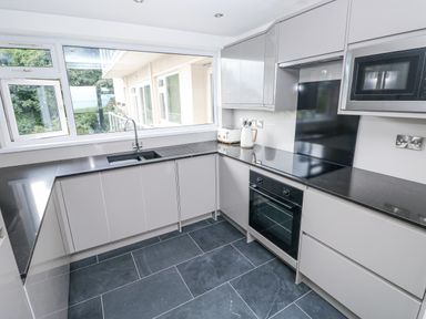 A kitchen with cabinets and appliances at Lifeboat Lookout in Tenby