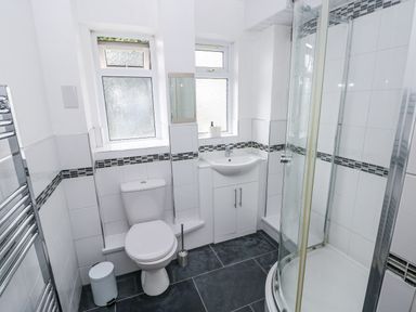 A bathroom with a shower enclosure and sink at Lifeboat Lookout in Tenby