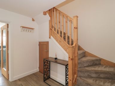 A hallway with a staircase and a table at 1 The Stables Highbridge