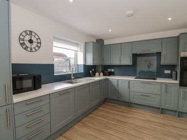 A kitchen with cabinets and a sink at 1 The Stables Highbridge