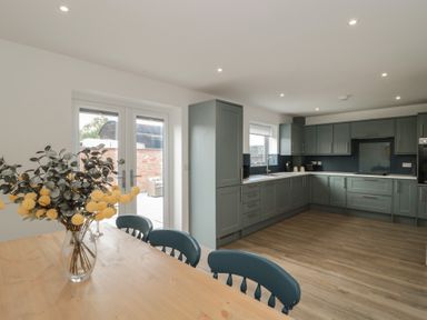 A kitchen with cabinets and a table with chairs at 1 The Stables in Highbridge