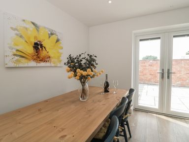 A dining room with a wooden table and chairs at 1 The Stables in Highbridge