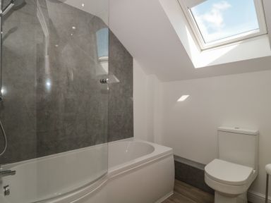 A bathroom with a bathtub and toilet at 1 The Stables in Highbridge