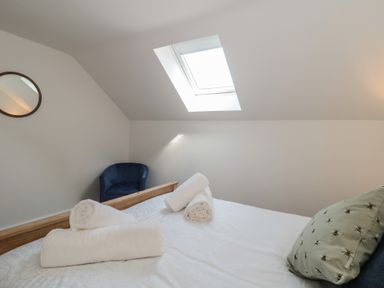 A bedroom with a bed and a chair at 1 The Stables Highbridge