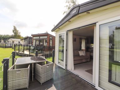 An outdoor area with a deck and seating at 22 Yealand in Carnforth