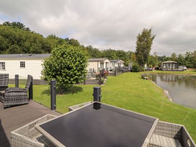 An outdoor view of holiday homes by a lake at 22 Yealand in Carnforth