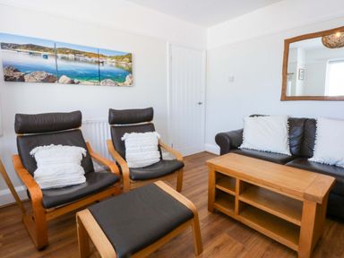 A living room with two armchairs and a coffee table at Swn Y Don