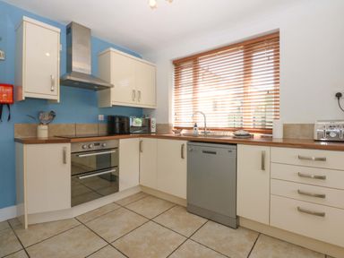 A kitchen with appliances and cabinets at Swn Y Don