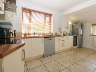 A kitchen with cabinets and appliances at Swn Y Don
