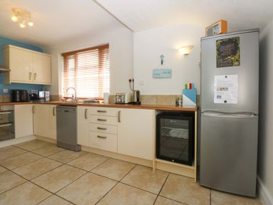 A kitchen with cabinets and appliances at Swn Y Don in 