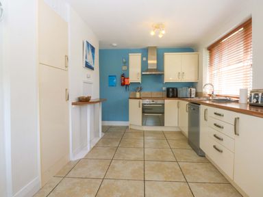 A kitchen with cabinets and appliances at Swn Y Don 