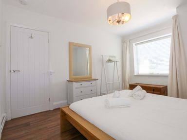 A bedroom with a bed, mirror, and dresser at Swn Y Don