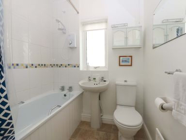 A bathroom with a bathtub, toilet and sink at Swn Y Don