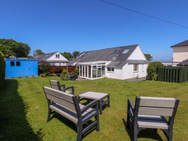 A garden with outdoor seating and a shed at Swn Y Don