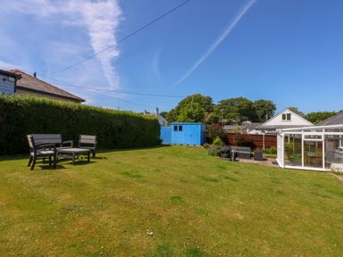 A garden with grass and patio furniture at Swn Y Don