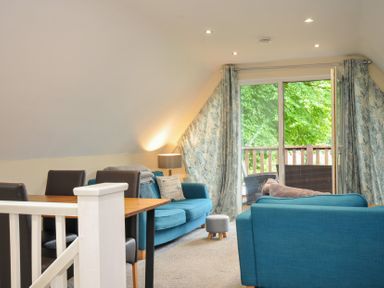 A living room with a sofa and dining table at Valley Lodge 2 Callington