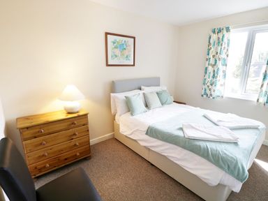 A bedroom with a bed and dresser at Valley Lodge 2 in Callington