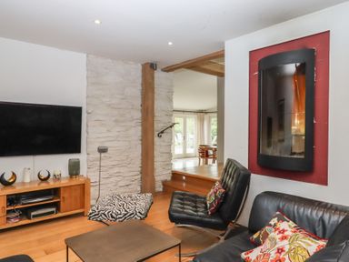 A living room with a television and a sofa at Lower Velwell Barn in Totnes