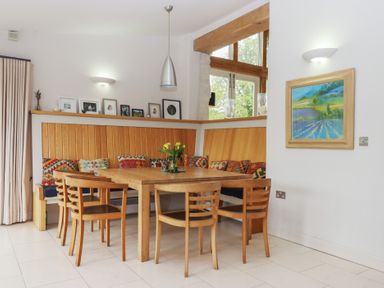A dining room with a table and chairs at Lower Velwell Barn in Totnes